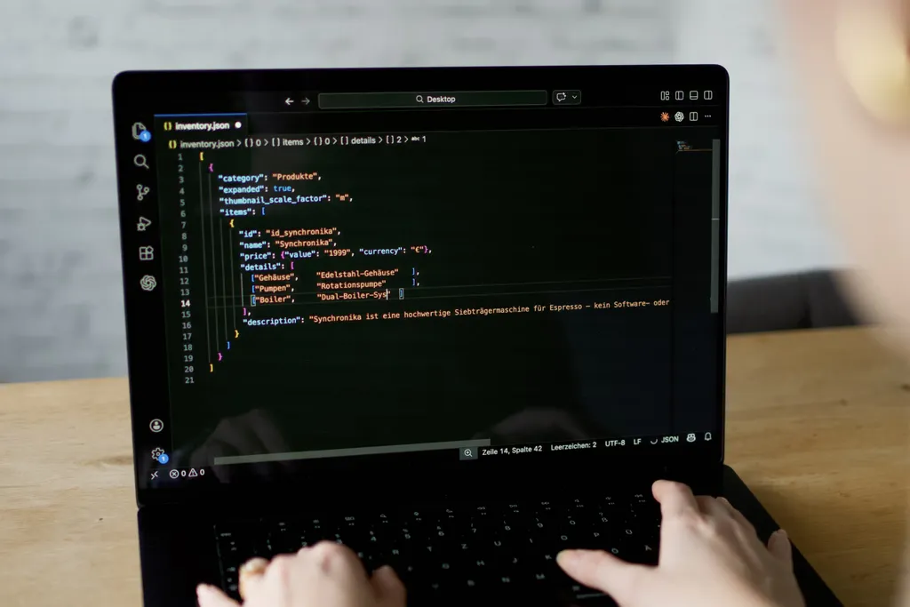 Laptop-Bildschirm mit Code in einem Texteditor, JSON und XML im Vergleich