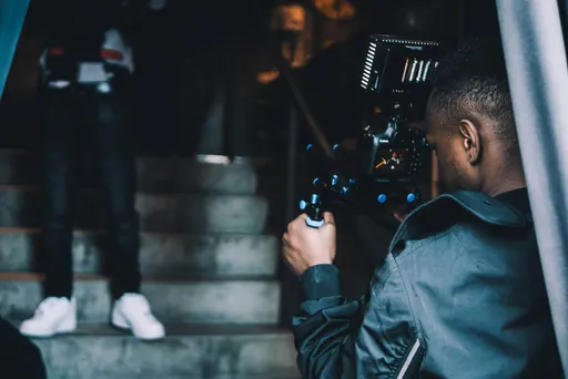 Person filmt eine andere Person bei einem Videodreh als Sinnbild für die Produktion technischer Anleitungen bei yntro.