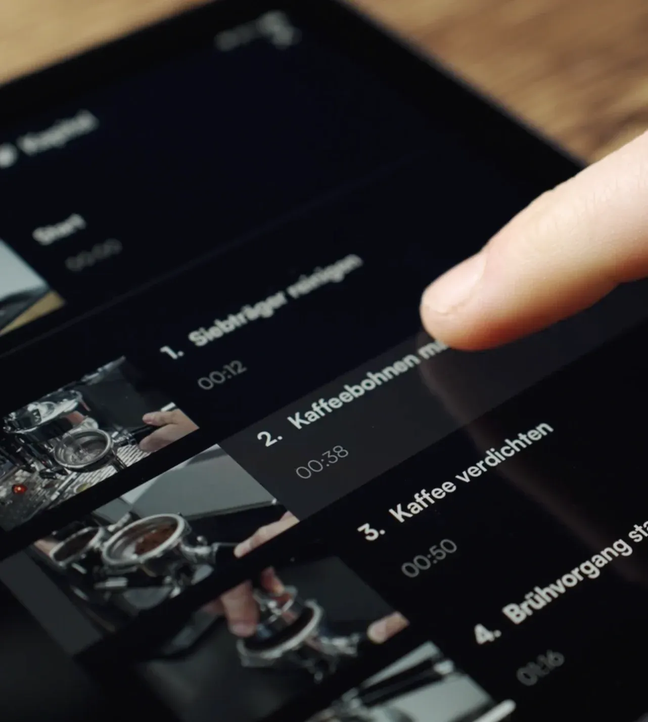 Finger tippt auf einem Tablet die Kapitelübersicht einer interaktiven Videoanleitung an.